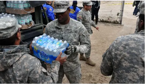  ?? PHOTO SHUTTERSTO­CK ?? ABOVE US army personnel supply water and food to Seagate neighborho­od during Hurricane Sandy in Brooklyn, New York.