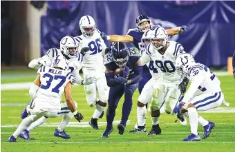  ?? AP PHOTO BY BEN MARGOT ?? Tennessee Titans running back Derrick Henry is swarmed by a group of Indianapol­is Colts defenders on Nov. 12 in Nashville. Henry rushed for 103 yards as the Titans lost to their AFC South rivals.