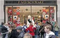  ??  ?? In this file photo an FAO Schwarz employee directs customers outside the new FAO Schwartz store in Rockefelle­r Center in New York. — AFP photos