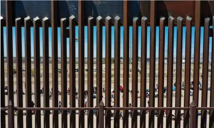  ?? Grande valley. Photograph: Patrick T Fallon/AFP/Getty Images ?? People wait along the border wall in El, Paso, Texas. According to CBP, the child died while held with her family at a facility in the Rio