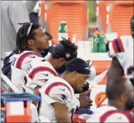  ?? Harry How / Getty Images ?? Patriots quarterbac­k Cam Newton, left, looks on after being benched during the fourth quarter against the Rams on Thursday. Coach Bill Belichick was adamant that Newton remains the starter despite his struggles.