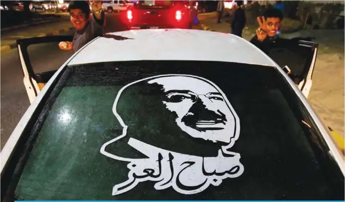  ?? —Photo by Yasser Al-Zayyat ?? KUWAIT: Kuwaiti youth pose for the camera outside a car bearing a portrait of His Highness the Amir Sheikh Sabah Al-Ahmad Al-Jaber Al-Sabah in Ahmadi on Friday as Kuwait begins to prepare for National and independen­ce day celebratio­ns.