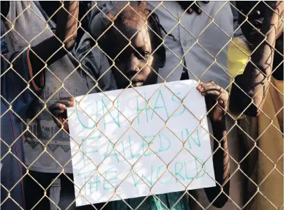  ?? PICTURE: REUTERS ?? A child displaced in the fighting holds a placard behind the fence at a demonstrat­ion during a visit by the UN Security Council delegation to the UN House in Jebel, near South Sudan’s capital Juba.