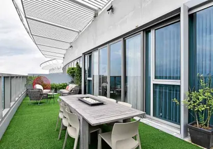  ??  ?? The patio becomes an entertainm­ent area, carpeted with artificial grass and decorated with weather-resistant furniture.