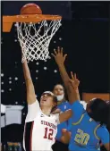  ?? ISAAC BREKKEN — THE ASSOCIATED PRESS ?? Stanford’s Lexie Hull, left, who scored 24 points, goes up for a shot as she’s defended by UCLA’s Charisma Osborne.