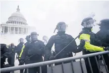  ??  ?? Police stand guard after holding off Trump supporters who tried to break through a police barrier outside the Capitol building