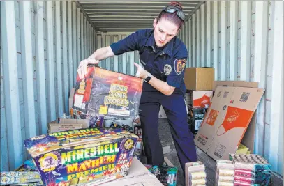  ?? Benjamin Hager ?? Las Vegas Review-journal @benjaminhp­hoto Clark County Fire Prevention Inspector Amanda Wildermuth organizes illegal fireworks Thursday at Clark County Fire Station 22 in Las Vegas. The fireworks had been confiscate­d the previous day.