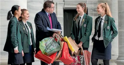  ?? PHOTO: MONIQUE FORD/STUFF ?? Samuel Marsden Collegiate School students Maggie Dai, left, Bella O’Meeghan, Imogen Skelton and Cici Davie present a 17,877-signature-strong petition calling for a plastic bag levy to Labour MP Grant Robertson outside Parliament yesterday.