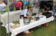  ?? TAWANA ROBERTS — THE NEWS-HERALD ?? Independen­t Chef Karina Ivie prepares a goat salad at the Downtown Painesvill­e Organizati­on farm-to-table event on July 26. More photos at Media.News-Herald.com