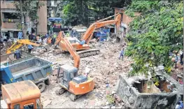  ??  ?? Rescue workers use machines to sift through the debris looking for survivors