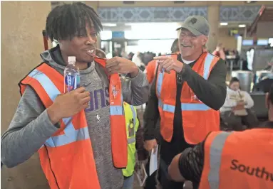  ??  ?? Richaun Holmes, left, of the Suns and Tom Chambers prepare for work at Sky Harbor Airport.