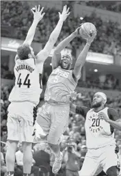  ?? Michael Conroy Associated Press ?? CLIPPERS FORWARD Montrezl Harrell shoots between Bojan Bogdanovic and Trevor Booker.