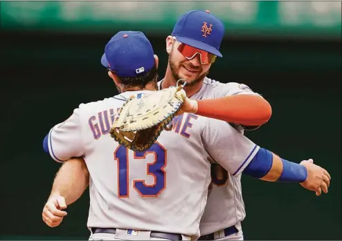  ?? Alex Brandon / Associated Press ?? New York Mets' Luis Guillorme (13) and Pete Alonso celebrate after a 4-1 win against the Washington Nationals at Nationals Park on Thursday in Washington.