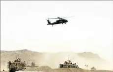  ?? STR ?? A U.S. military helicopter flies over the site of a suicide bomb that struck a NATO convoy Wednesday in Kandahar south of Kabul, Afghanista­n.