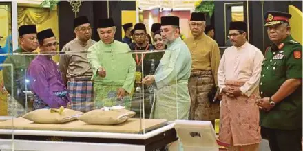  ?? BERNAMA PIC ?? Yang di-Pertuan Agong Sultan Muhammad V looking at items on display at the Raja Kita exhibition at the Royal Museum in Kuala Lumpur yesterday. With him are Deputy Prime Minister Datuk Seri Dr Ahmad Zahid Hamidi and Communicat­ions and Multimedia...