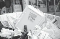  ?? SPENCER PLATT, GETTY IMAGES ?? The New York City Council has voted to ban polystyren­e foam food containers, like this one in a trash can, effective July 1, 2015.