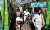  ??  ?? People move through a disinfecti­ng tunnel at a vegetable and fruit market as government-imposed a nationwide lockdown to contain the outbreak of the Coronaviru­s, in Islamabad, Pakistan, Thursday