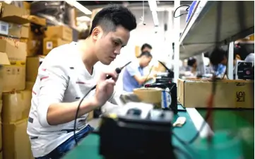  ??  ?? Photo shows an employee working at a company producing robots in Shenzhen in southern China’s Guangdong province.