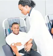  ?? CONTRIBUTE­D ?? Oneiley Williams, security and safety analyst at Digicel, gets some help from nurse Patricia Thompson-Johnson as he makes his donation to the Blood Bank. In recognitio­n of World Blood Donor Day 2017, Digicel partnered with the National Blood...