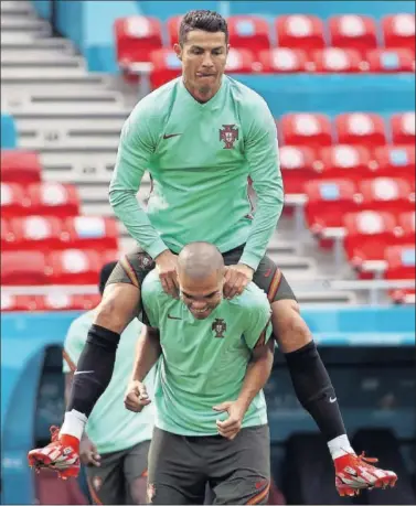  ??  ?? Cristiano salta encima de Pepe en un entrenamie­nto de Portugal.