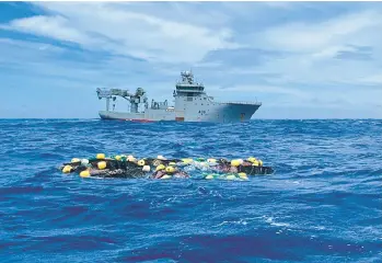  ?? NEW ZEALAND POLICE ?? Dozens of bricks of cocaine thought to be headed to Australia bob on the surface of the Pacific Ocean with a Royal New Zealand Navy vessel nearby. Police on Wednesday said they found 3.5 tons of the drug, worth $316 million, at a floating transit point after being dropped there by an internatio­nal smuggling syndicate. No arrests have been made.