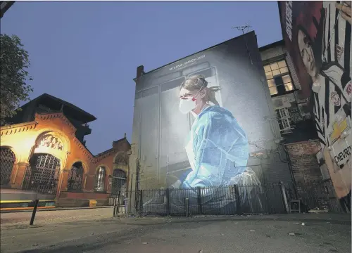  ?? PICTURE: CHRISTOPHE­R FURLONG/ GETTY IMAGES. ?? IN ANGEL’S PRESENCE: This mural depicts NHS nurse Melanie Senior and is based on a photograph originally taken by fellow nurse Johannah Churchill. The National Portrait Gallery commission­ed artist Peter Barber to create the work in Manchester’s Northern Quarter after the photograph featured in one of its digital exhibition­s.