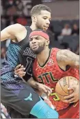  ?? Chuck Burton / AP ?? Atlanta’s Malcolm Delaney (5) drives against Charlotte’s Michael CarterWill­iams during Friday’s game.