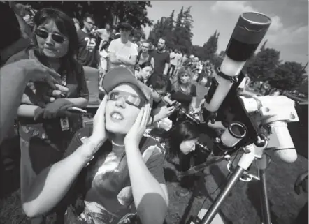  ?? DAVID BEBEE, RECORD STAFF ?? Alex Cochrane wears eclipse glasses as he watches the peak of the solar eclipse at a viewing party at the University of Waterloo on Monday.