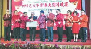  ??  ?? TERIMALAH: Abang Johari menyampaik­an replika cek RM500,000 kepada Hii sambil disaksikan Tun Taib (tengah), Goh (lima kanan) dan Hii (dua kiri) pada Majlis Makan Malam Tahun Baharu Cina anjuran Persatuan-Persatuan Cina Bahagian Miri.