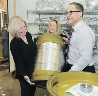  ?? GAVIN YOUNG ?? Premier Rachel Notley and Finance Minister Joe Ceci try lifting a keg with Cold Garden Brewery owner Kris Fiorentino at the Inglewood business on Monday.