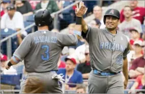  ?? CHRIS SZAGOLA — THE ASSOCIATED PRESS ?? Arizona Diamondbac­ks’ Daniel Descalso, left, celebrates as he scores with Jorge De La Rosa, right, on a double by Paul Goldschmid­t during the seventh inning against the Phillies on Saturday.