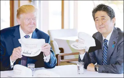  ?? REUTERS ?? US President Donald Trump and Japanese Prime Minister Shinzo Abe hold hats they signed, reading ‘Donald & Shinzo Make Alliance Even Greater’ before a round of golf at Kasumigase­ki country club in Kawagoe yesterday.