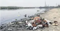  ??  ?? Filthy shore . . . A trail of garbage lines the Yamuna River in New Delhi.