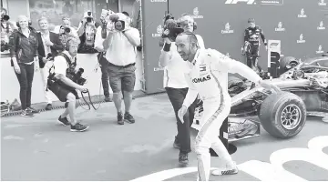  ??  ?? Mercedes’ British driver Lewis Hamilton celebrates after winning the German Formula One Grand Prix at the Hockenheim racing circuit in Hockenheim. — AFP photo