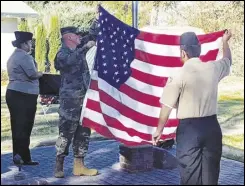  ?? VALLEY PRESS FILES ?? Sgt. Becker (center) from the US Army recruiting office in Lancaster, assists Antelope Valley Union High School Navy Junior ROTC cadets with the US flag during the 2019 Veterans Day ceremony at Lancaster Cemetery.
