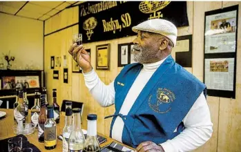  ?? JAY PICKTHORN PHOTOS FOR THE WASHINGTON POST ?? Lawrence Diggs, founder of the Internatio­nal Vinegar Museum in Roslyn, S.D., with some of the 300 bottles in its collection. Diggs’ expertise as a consultant on vinegar led the town to found the museum to draw visitors.