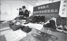  ?? ZHANG HAILONG / FOR CHINA DAILY ?? Dongguan Customs officials in Guangdong province seize shipments of counterfei­t goods, involving multiple brands.