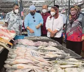  ?? (Foto Nuraliawat­i Sabri/bh) ?? Sulaiman (dua dari kiri) bersama Norena (dua dari kanan) melakukan meninjau harga jualan ketika Sesi Walkabout di Pasar Awam Bachang, Melaka, semalam.