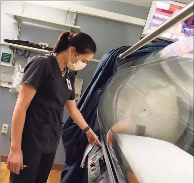  ?? Tyler Sizemore / Hearst Connecticu­t Media ?? Dr. Sandra Wainwright works on the the hyperbaric oxygen chamber at Greenwich Hospital, which is being used to treat COVID-19 patients.