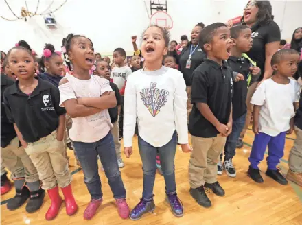  ?? MIKE DE SISTI / MILWAUKEE JOURNAL SENTINEL ?? Kindergart­ners Ivionna Winston (center), Tamelah Christian (left of Winston) and Ezekiel Reed (right of Winston) recite the scholars' declaratio­n at Martin Luther King Jr. elementary school.