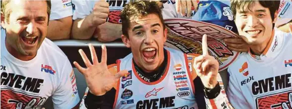  ??  ?? Marquez (tengah) ketika merai kejayaanny­a di GP Jepun sekali gus merampas gelaran juara dunia, Ahad lalu.