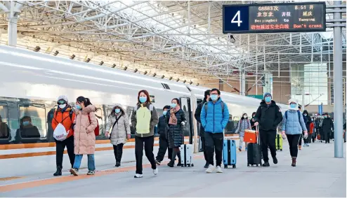  ?? Cnsphoto ?? 1 de enero de 2021. Los pasajeros del tren de alta velocidad G8883, que circula por el tramo Beijing-Yanqing de la línea Beijing-Zhangjiako­u, ingresan a la Estación de Trenes del Norte de Beijing.