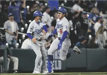  ?? DAVID ZALUBOWSKI ?? LOS ANGELES DODGERS’ ZACH MCKINSTRY (RIGHT) runs around third base on the way to notching an inside-the-park home run off Colorado Rockies relief pitcher Mychal Givens in the eighth inning of a game Saturday in Denver.