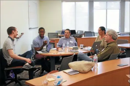  ?? PHOTO COURTESY OF THE CHESTER COUNTY ECONOMIC DEVELOPMEN­T COUNCIL ?? Area entreprene­urs had just 54 hours to take a business idea from concept to start-up, during the Techstars Startup Weekend, held June 1-3 at West Chester University. Shown here, one of the teams works on its pitch. Of the 25 pitches made, seven ideas...