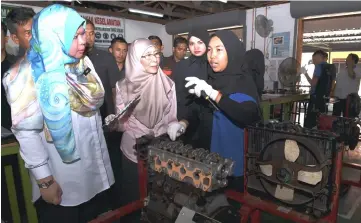  ??  ?? Dr Wan Azizah (centre) listening to Nurul Aishah Shamsudin, 18, at the automotive workshop. At left is Rina. — Bernama photo