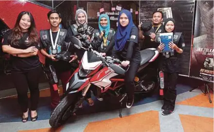  ?? PIC BY KHAIRUL AZHAR
AHMAD ?? ‘J Revolusi Watch and Win Exclusive Items of Zul Ariffin and Jay Zulkarnain’ contest grand-prize winner Nur Izzah Sabrina Azlan posing on her Ducati Hypermotar­d bike. With her are Infinitus Production­s Sdn Bhd marketing manager Jeannie Lim (left) and...