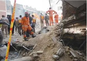  ?? AP PHOTO/MUHAMMAD ZUBAIR ?? Rescue workers clear rubble and search for bodies Tuesday at the site of Monday’s suicide bombing in Peshawar, Pakistan.