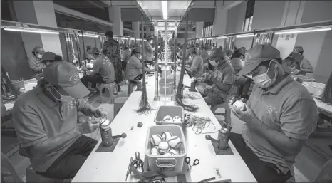  ?? JIANG WENYAO / XINHUA ?? Workers make baseballs at a factory in Yunnan province in May. It’s one of the local poverty-reduction programs to better safeguard people’s livelihood­s, one of the issues the country emphasizes for steady economic momentum.