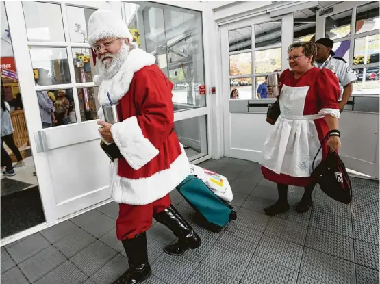  ?? Elizabeth Conley / Houston Chronicle ?? Mr. and Mrs. Claus arrive at the Children’s Museum of Houston on Saturday for an afternoon of merrymakin­g and last-minute gift requests.