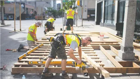  ?? DAX MELMER ?? Brandon Kolody, co-owner of My Homemade Home Inc., works with his crew to build a patio outside Sidebar Lounge on Pelissier Street in downtown Windsor on Tuesday under Stage 2 reopening guidelines. There were 10 additional coronaviru­s cases in the region reported Tuesday.